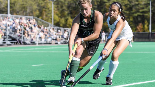 A Dartmouth field hockey player stickhandles past an opponent during a game